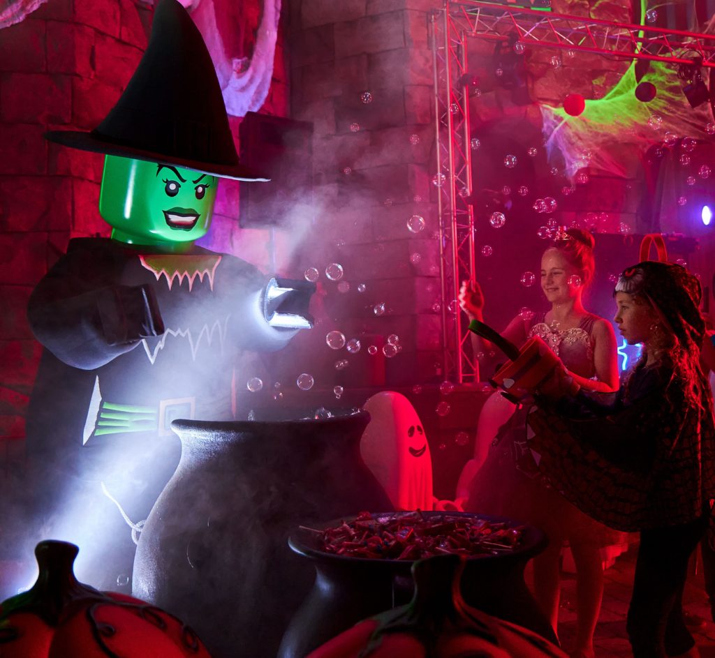 LEGOLAND presents Monster Party: LEGO witch brewing bubbles in her caldron while visitors watch